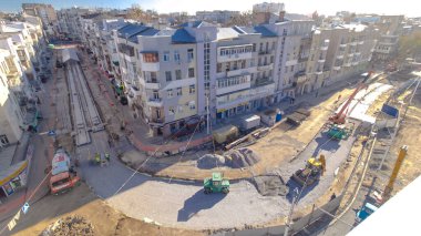 Beton, yol onarım şantiyesinde çok sayıda işçi ve mikser zaman ayarlı çalışıyor. Tramvay raylarının yeniden inşası. Tüm gün boyunca hava üst görünümü