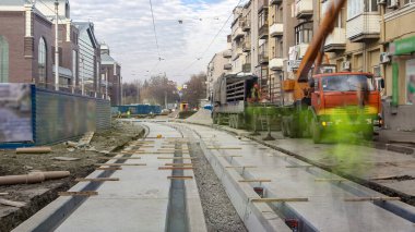 Tramvay rayları üzerinde yol timelapse beton tabaklarda vinç onların kamyondan boşaltma aşamasında. Tramvay yeniden inşası süreci izler