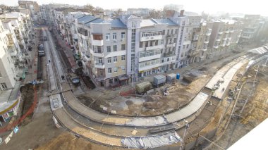 Beton yol yapımında çok sayıda işçi ve mikser makinesi, vinç, traktör zaman ayarlı çalışır. Tramvay raylarının yeniden inşası. Asfalt değirmeninin hava üst görünümü