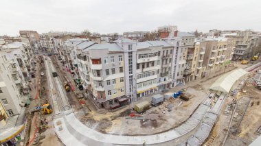 Yol yapımı için beton kaplayan bir sürü işçi ve mikser makinesi, vinç, traktör zaman ayarlı. Tramvay raylarının yeniden inşası. Bulutlu bir günde hava üst görünümü