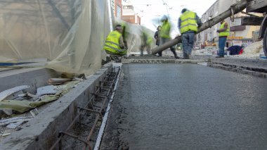 Çelik takviyesi yaptıktan sonra beton karıştırıcı zaman aşımına uğrayarak yolu hızlandırmak için hazır beton dökülüyor. Çadırla kaplı yeni raylar. Tramvay raylarının yeniden inşası