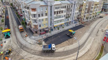 Yol onarım alanında asfaltlama sırasında kaldırım taşı, paten ve kamyon tarafından püskürtülmüş. Tramvay raylarının havadan görünüşü. Yol yapım ekipmanları. Yol onarımı yapan inşaat işçileri.