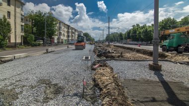 Turuncu titreşimli sıkıştırıcılar yol yapımında ve tamir zamanlarında ezilmiş taşların üzerinde yuvarlanıyor. Tramvay raylarının yeniden inşası