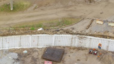 Şehir karayolu inşaatı zamanındaki tramvay rayları için koruyucu maske takviyesi olan işçilerin hava görüntüsü. Tramvay raylarının yeniden inşası.