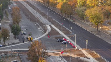 Bulvar ve tramvay raylarının yeniden inşa edildiği bir inşaat alanı. Yeni asfalt yol kaldırımı döşedikten sonra yol işaretleri, yukarıdan işçiler ve makineler