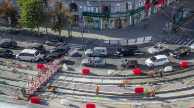 Onarım street timelapse üzerinde çalışır. Bir şehir sokak üzerinde yeni tramvay rayların döşenmesi. Yeni modern demiryolu rayları tramvaylar için montajı. Hava üstten görünüm. Tramvay parça kavşak üzerinde yeniden inşası