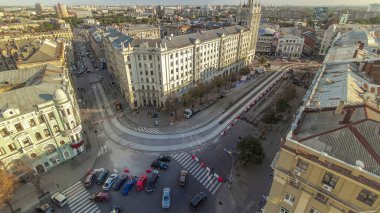 Ukrayna 'nın Kharkiv kentindeki tarihi binaların zaman çizelgesine sahip Anayasa Meydanı. Yol kavşağında trafik vardı ve evin yakınındaki inşaat alanında da bir kule vardı. Çatıdan görüntüle