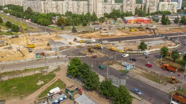 Birkaç endüstriyel makineli zaman ayarlı geniş yol şantiyesinin havadan görüntüsü. Toprak taşıma ekipmanları, kamyonlar ve vinçler. Yeni metro istasyonu binası