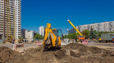 Endüstriyel kazı alanı kazıyor ve inşaat alanındaki eski yol zamanının parçalarını temizliyor. Büyük bir şehirde tramvay raylarının yeniden inşasına hazırlık