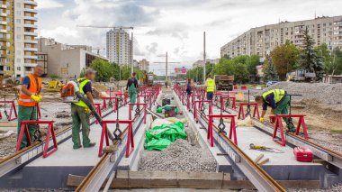 Kurulum aşamasındaki tramvay rayları ve zaman dilimindeki beton plakalara entegrasyon. Tramvay raylarının yeniden inşası. Bulutlu gökyüzü