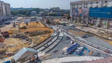 Yol inşaatında buldozerler ve kazıcılar üzerinde çalış. Alt tabakada ezilmiş taş. Destek faaliyetleri ve endüstriyel makineler. Tramvay raylarının yeniden inşası. Yukarıdan hava üstü görünümü