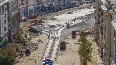 Beton, yol yapımında üniformalı, karıştırıcı makineli ve vinçli zaman ayarlı birçok işçiyle çalışıyor. Tramvay raylarının yeniden inşası