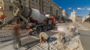 Beton işleri ve yol inşaatı için gerekli ayarlamalar. Üniformalı ve mikser makineli bir sürü işçi var. Tramvay raylarının yeniden inşası