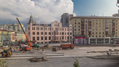 Concrete works for road construction with many workers in uniform timelapse. Mixer, crane and bulldozer working on intersection. Reconstruction of tram tracks