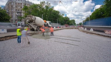 Tramvay rayları onarımı ve bakım zamanı olan bir yol inşaatı. Beton, kavşağın ortasında mikserle çalışıyor. Yeni toplu taşıma için demiryolu raylarının değiştirilmesi