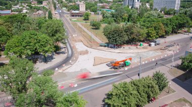 Tramvay rayları onarılan ve panoramik panoramik zaman ayarlı yol inşaatı. Beton kavşağın orta kısmında işe yarar. Metal ızgara boşaltılıyor