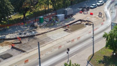 Road construction site with tram tracks repair and maintenance aerial timelapse. Concrete works with mixer on a middle part of intersection. Traffic on a street clipart