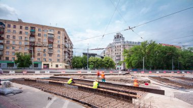 Tramvay rayları onarımı ve bakım zamanı olan bir yol inşaatı. Beton kavşağın orta kısmında işe yarar. Beton taban için metal ızgara