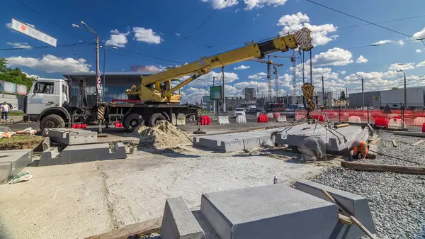 Vinç yol inşaat site timelapse, beton plaka yükleme. Kavganın ve üniforma ile sanayi işçileri. Sokak şehir tramvay yeniden inşası izler