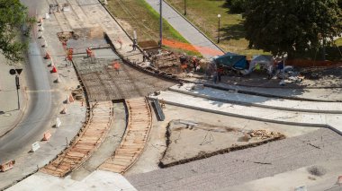 Tramvay rayları onarımı ve bakım havası olan bir yol inşaatı. Turuncu karıştırıcı kavşağın ortasına beton döküyor. Yeni toplu taşıma için demiryolu raylarının değiştirilmesi