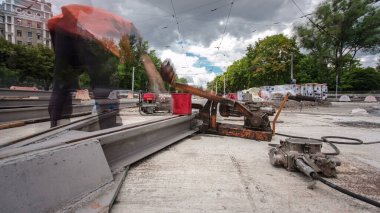 Tramvay rayları onarımı ve bakım zamanı olan bir yol inşaatı. Şehir caddesinde yeni raylar kesiyorum. Kavşağın ortası. Yeni toplu taşıma için demiryolu raylarının değiştirilmesi
