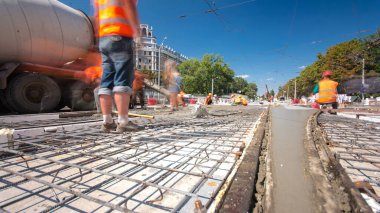 Beton yol yapım birçok işçi ve mikser timelapse hyperlapse ile çalışıyor. Harç metal takviye için dökme. Kaplama ve koruyucu filtre püskürtücü tarafından. Tramvay parça yeniden inşası