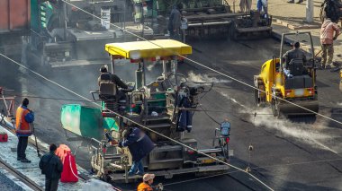 Çalışan işçiler finişer makineleri ve bahşiş asfalt yol yapımı sırasında ve tamir timelapse izleme ile çalışır
