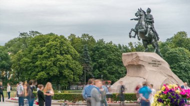 Bronz Süvari, Rus İmparatoru Büyük Peter 'a anıtsal bir övgü. Rusya, Saint Petersburg 'un göbeğinde, turistler fotoğraf çekiyor. Arkaplanda yeşil ağaçlar