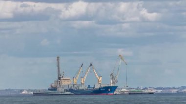 Nehrin ortasında bir yük gemisini endüstriyel vinçlerle yükleyip boşaltmak. İthalat ve ihracat işi lojistik şirketi. Sanayi ve Ulaştırma konsepti. Lizbon, Portekiz