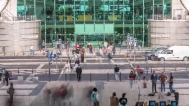 İnsanlar, Vasco da Gama alışveriş merkezinin önünden geçen bir zebrayla karşıdan karşıya geçiyorlar. Kavşakta ve otobüs durağında trafik vardı. Lizbon, Portekiz