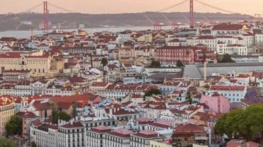 25 Nisan 'da Tagus Nehri ve Köprüsü veya Portekiz' in Lizbon şehrinde bulunan Orange Roofs 'un üzerindeki 25. Gün batımında Miradouro da Senhora do Monte 'den panoramik manzara