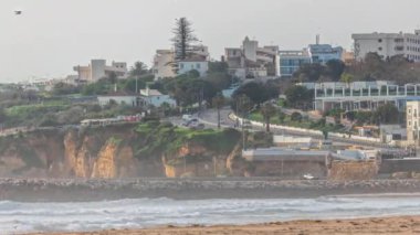 Sabah Algarve, Portekiz 'deki Lagos' taki güzel Meia Praia plaj zamanının hava manzarası. Uçurumlarda bir sürü ev var. Kavisli yol ve taşlanmış rıhtımla manzarayı kapat