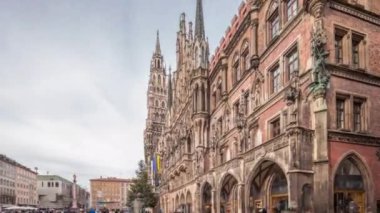 Münih 'te Marienplatz' ın kuzey kesimindeki Neues Rathaus binasının ana cephesi. Önde Fischbrunnen çeşmesi var. Bulutlu gökyüzü. Bavyera, Almanya.