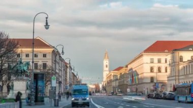 Ludwigstrasse ve St.Ludwig Kilisesi Odeonsplatz zaman diliminden. Gün batımında birçok araba ve otobüsle kavşakta trafik vardı. Münih, Almanya