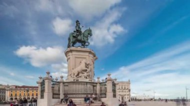 Comercio Ticaret Meydanı 'nda pratik yap. Kral 1. Jose 'nin heykeli hiperhızlandırılmış. Kral sembolik olarak yoluna çıkan yılanları eziyor. Bulutlu bir gökyüzü ve arka planda renkli evler. Lizbon, Portekiz.