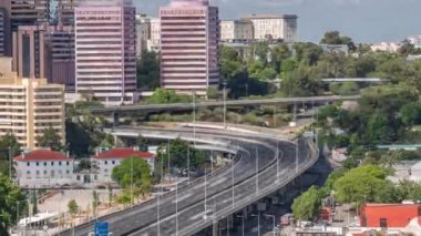 Yüksek perspektifli IP7 otoyolu yükseltilmiş yol, virajlı hayvanat bahçesinin havalanma zamanı. Birçok araba trafiği ve yüksek renkli binalar var. Gökyüzündeki bulutlar. Lizbon, Portekiz