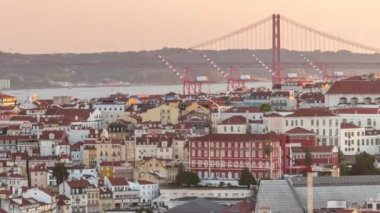 25 Nisan 'da Tagus Nehri ve Köprüsü veya Portekiz' in Lizbon şehrinde bulunan Orange Roofs 'un üzerindeki 25. Gün batımında Miradouro da Senhora do Monte 'den panoramik manzara