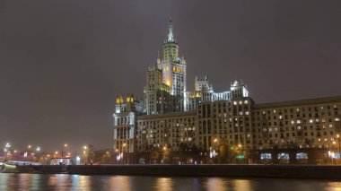 Gece Kotelnicheskaya Rıhtımı 'ndaki ünlü bina: Moskova' daki Yedi Kız Kardeş Binası 'ndan biri. Moskova Nehri 'nde yansıması olan hiperlapse. Rusya