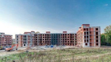 Construction site with buildings under construction and multi-storey residential homes timelapse hyperlapse. Housing renovation concept. Excavators during formworks