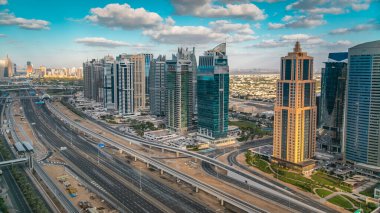 Dubai marina gökdelenlerinin ve Jumeirah göl kulelerinin hava panoramik manzarası Sheikh zayed yolundaki trafiği gösteriyor. Bulutlu mavi gökyüzü ile gün batımı zamanı