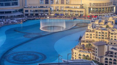 Akşam havası manzaralı şehir merkezinde dans eden fıskiyeler ve gün batımında Dubai, BAE 'de insan yapımı bir göl zamanlamasında..