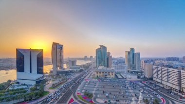 Günbatımında Dubai deresi panoramik manzarası. Tekneler, yatlar ve yollarda trafik ve araba parkı olan modern binalar. Yukarıdan hava üstü görünümü