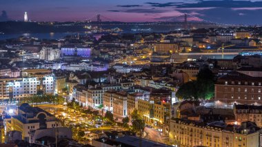 Lizbon 'da gün batımından sonra şehir merkezinin sonbahar gününden geceye geçiş zamanlarında kırmızı çatıları olan panoramik manzarası, Portekiz. Miradouro da Nossa Senhora do Monte bakış açısından üstten görünüm