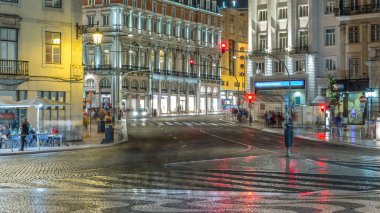 Dom Joao da Camara Square from Praca Dom Pedro IV or Rossio Square in Lisbon downtown night timelapse. Illuminated building and traffic on the road intersection