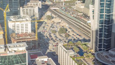 Aerial view of traffic on Business Bay with parking timelapse. Big modern city with skyscrapers and construction site. Downtown Dubai, United Arab Emirates. clipart