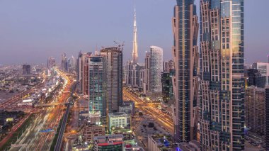 Dubai, Bae gece geçiş timelapse için şeyh zayed yol gün modern gökdelenler ve trafik ile Akşam silueti. İş koyu mimarisinin havadan görünümü.