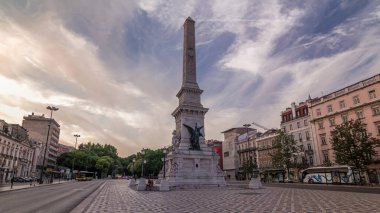 Portekiz 'deki Lizbon Restoranlar Meydanı' nda Restoratörlerin zaman atlaması anıtı. Çevredeki tarihi binalar ve gün batımından önce renkli gökyüzü