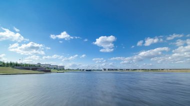 Astana, Kazakistan. Keyif teknesinden Astana 'da Ishim nehrinde hareketli bir seyahat görüntüsü. Mavi gökyüzü ve bulutlarla dolu bir yaz gününde. Bulanık hareket