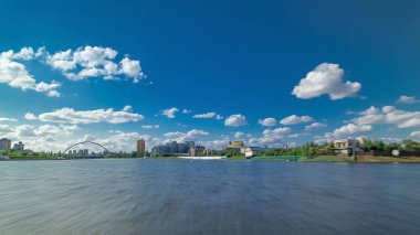 Astana, Kazakistan. Keyif teknesinden Astana 'da Ishim nehrinde hareketli bir seyahat görüntüsü. Mavi gökyüzü ve bulutlarla dolu bir yaz gününde. Bulanık hareket