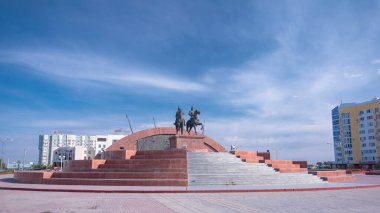 Timelapse Hiperlapse Kazak Kahramanlar Anıtı Makhambet Utemisov ve Isat 'ın Atyrau Şehrinde. Güneşli bir günde Kazakistan 'da Mavi Bulutlu Gökyüzüne karşı haraç açılır